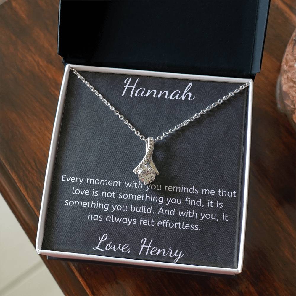 Necklace with a heart-shaped pendant in a gift box with a personalized message.