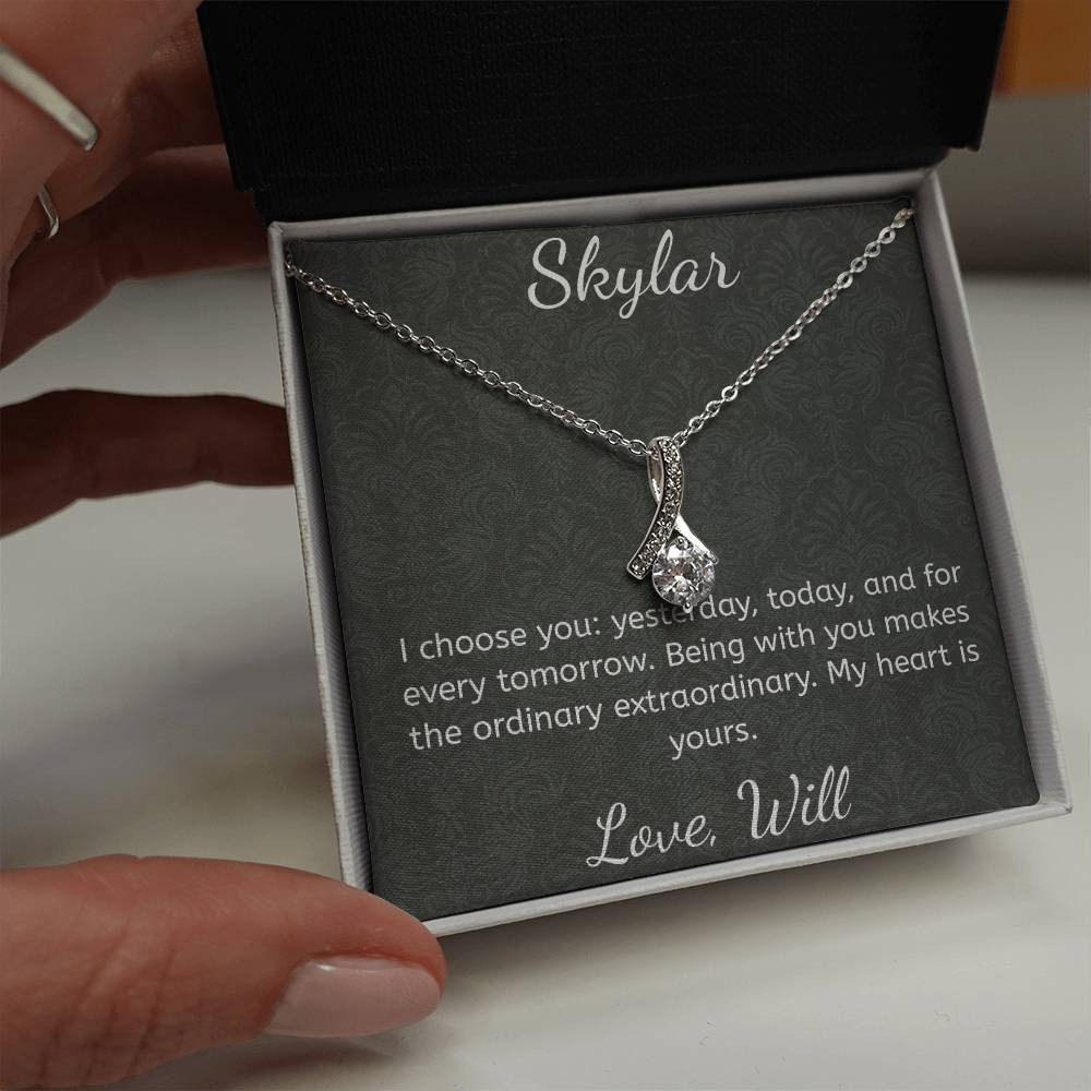 Silver necklace in a box with a sentimental message, held by a hand.