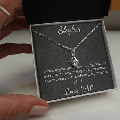Silver necklace in a box with a sentimental message, held by a hand.