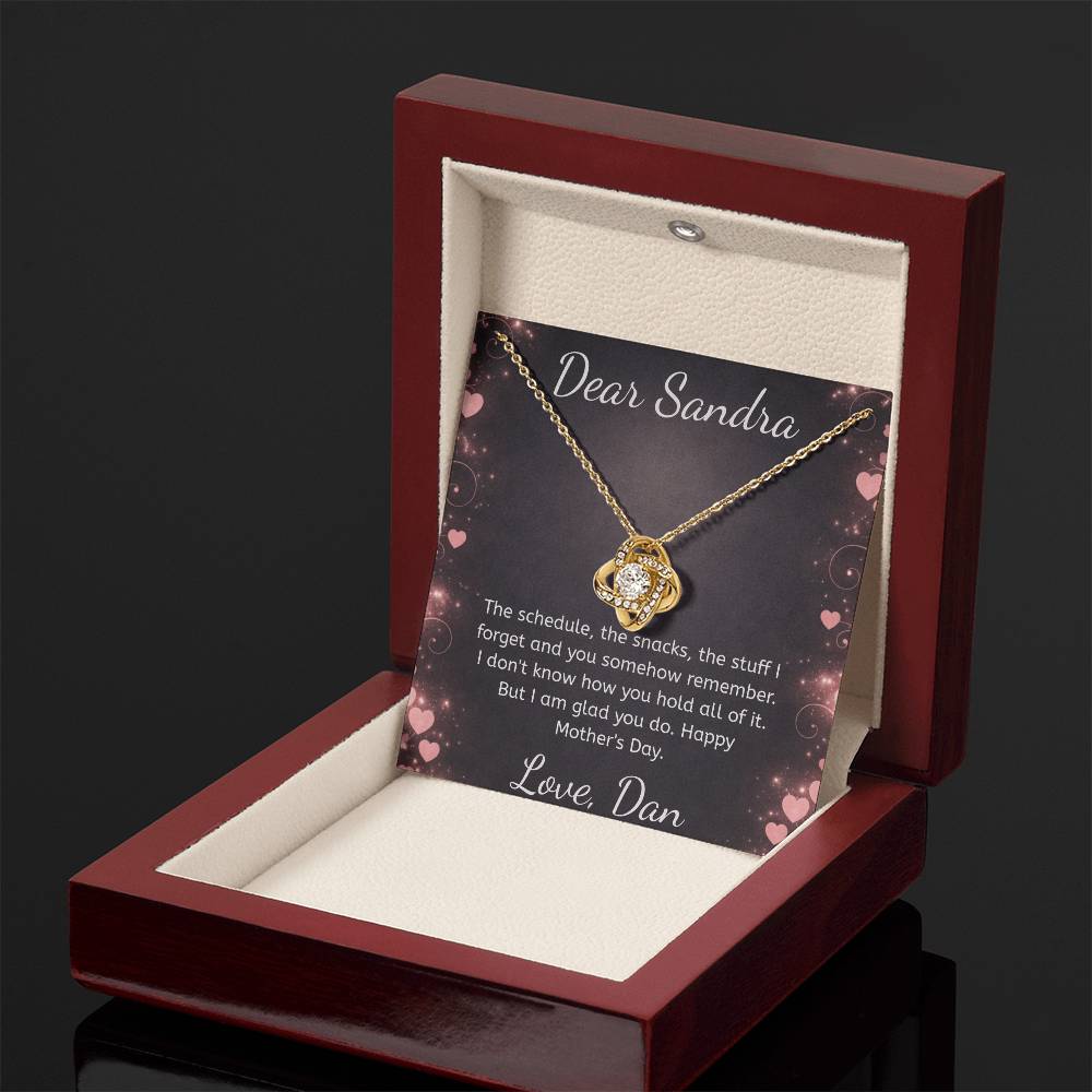 Jewelry box with a gold necklace and card inside, on a dark background