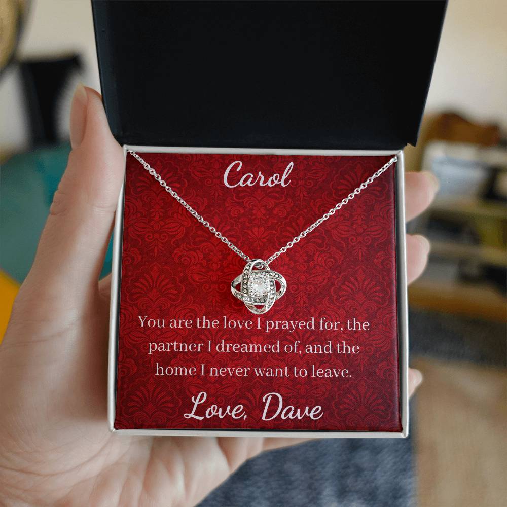 Necklace in a red box with personalized message, held by a hand.