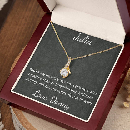 Gold necklace on a personalized card with a message, displayed in an open jewelry box.